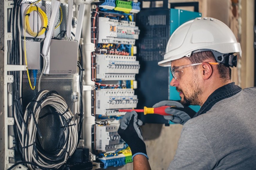 Technician testing a wired control panel on the shop floor