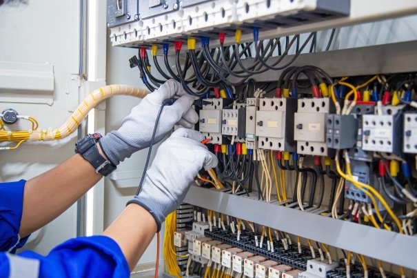 Technician wiring an industrial control panel