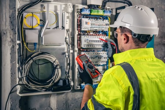 Technician testing a wired control panel with a multimeter
